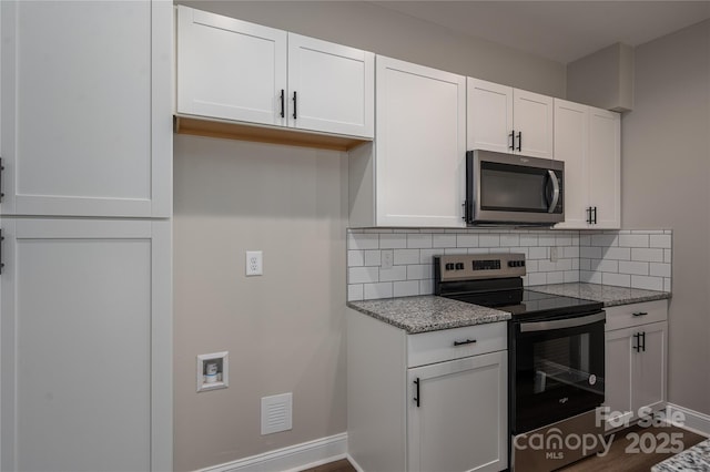 kitchen with visible vents, baseboards, white cabinetry, appliances with stainless steel finishes, and decorative backsplash