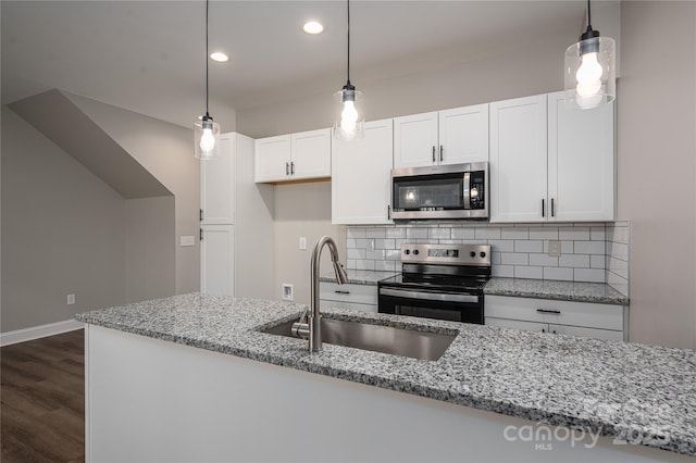 kitchen with stainless steel appliances, a sink, white cabinetry, backsplash, and dark wood-style floors