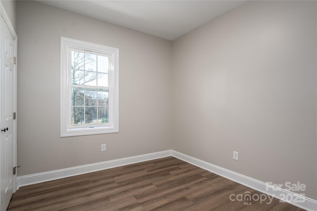 empty room with baseboards and dark wood-style flooring