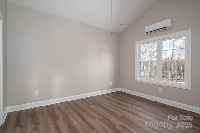 empty room with vaulted ceiling, an AC wall unit, dark wood finished floors, and baseboards