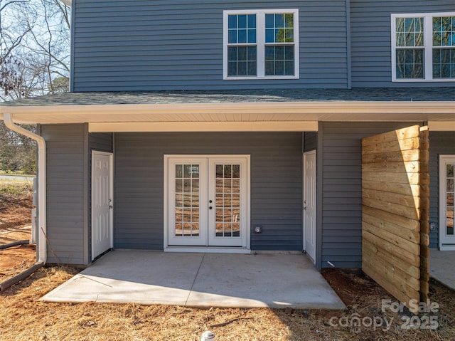 entrance to property with french doors and roof with shingles