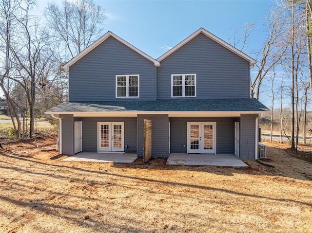 back of property with french doors, roof with shingles, and a patio