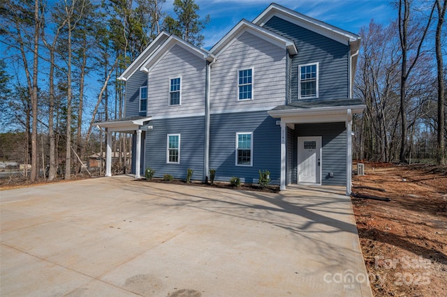 view of front facade featuring concrete driveway and central AC unit