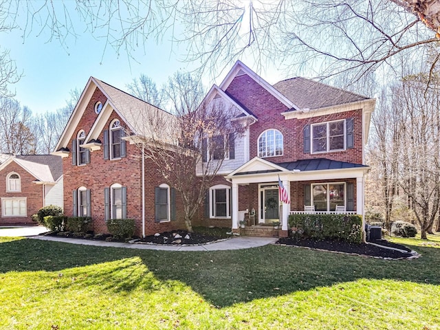 view of front of house with covered porch, brick siding, a front lawn, and central air condition unit