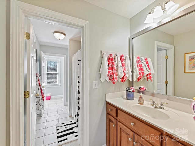 bathroom with vanity, baseboards, and tile patterned floors