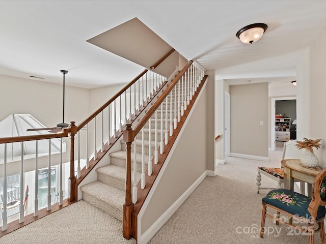 stairway featuring carpet, baseboards, and ceiling fan