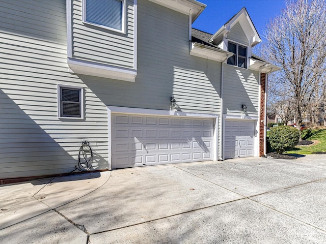 view of side of home with a garage and concrete driveway