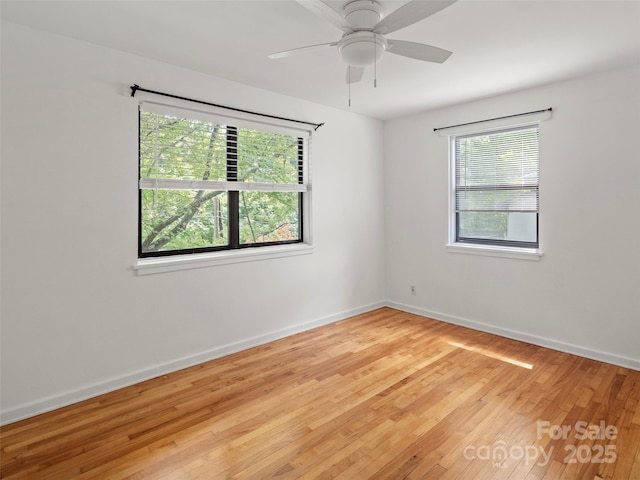 empty room featuring a ceiling fan, baseboards, and wood finished floors