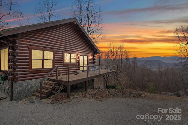 back of house featuring a deck with mountain view and log exterior