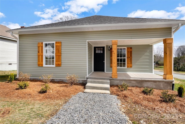 bungalow-style home featuring crawl space, a porch, and roof with shingles