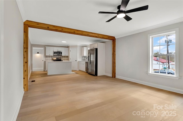 unfurnished living room with a ceiling fan, visible vents, baseboards, crown molding, and light wood-type flooring