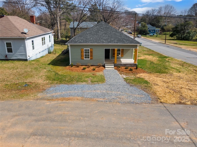 view of front of property featuring a porch, a front yard, and a shingled roof