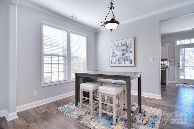 dining area featuring visible vents, baseboards, dark wood finished floors, and crown molding