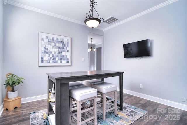 dining area with visible vents, baseboards, dark wood finished floors, and ornamental molding