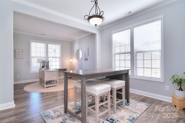 dining room featuring crown molding, wood finished floors, a healthy amount of sunlight, and baseboards