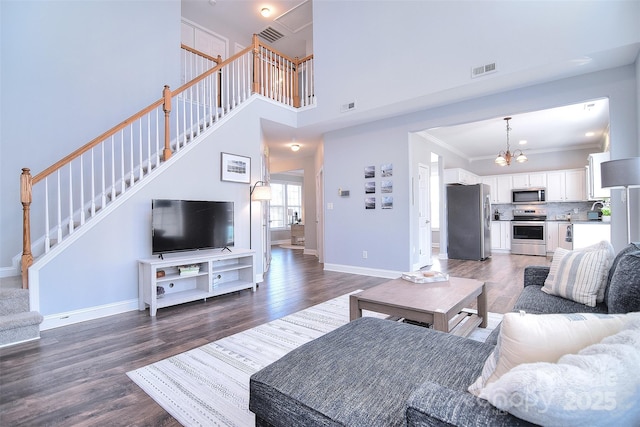 living room featuring stairs, visible vents, dark wood-style flooring, and ornamental molding