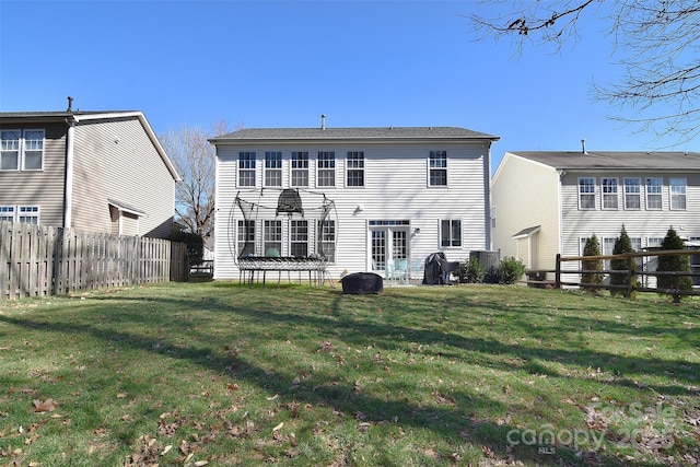 rear view of house with a lawn and a fenced backyard