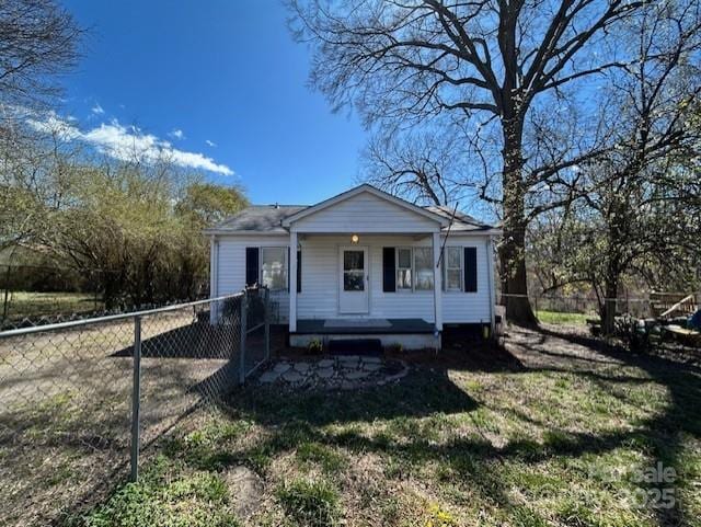 bungalow with a porch, a front lawn, and fence