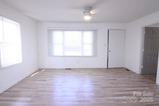 unfurnished room with a healthy amount of sunlight, light wood-style flooring, and ceiling fan