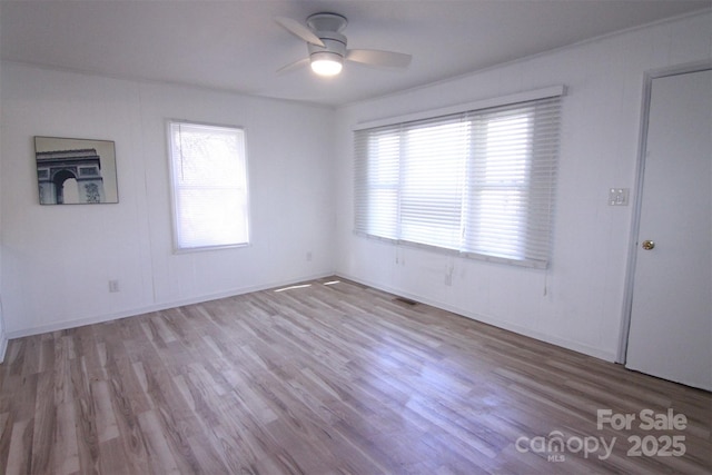 spare room featuring visible vents, wood finished floors, and a ceiling fan