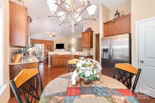 dining space with lofted ceiling, dark wood-style flooring, and ceiling fan with notable chandelier