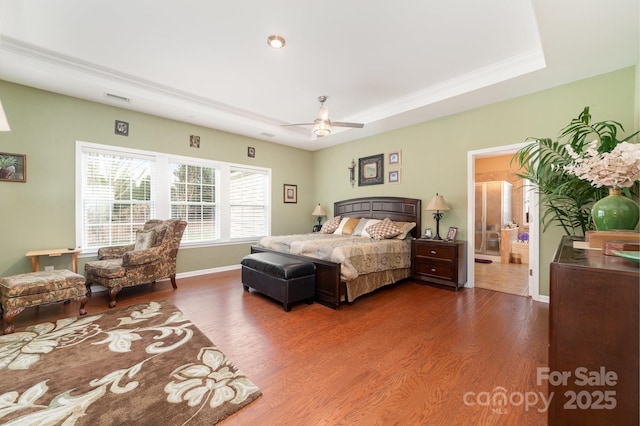 bedroom with visible vents, baseboards, connected bathroom, ceiling fan, and wood finished floors