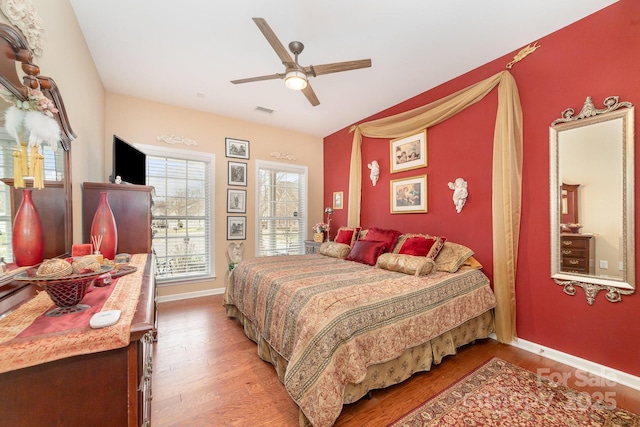 bedroom featuring a ceiling fan, light wood-style flooring, visible vents, and baseboards