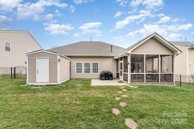 rear view of house with a yard, a sunroom, a patio area, a fenced backyard, and an outdoor structure