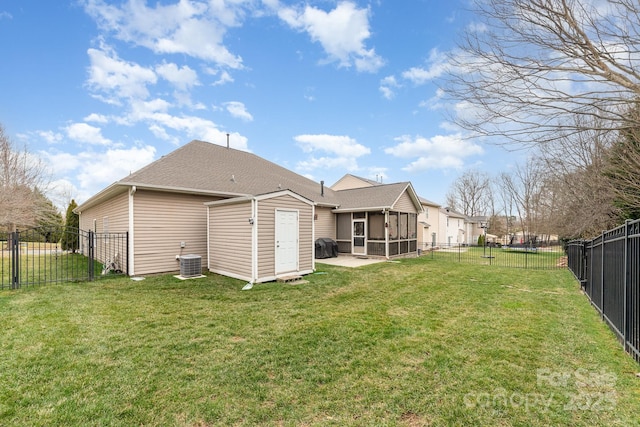 rear view of property featuring a sunroom, a fenced backyard, and a lawn