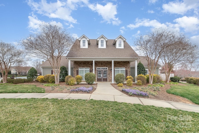 cape cod home with a shingled roof, fence, and a front lawn