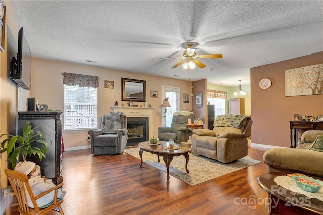 living room with visible vents, a healthy amount of sunlight, a fireplace, and wood finished floors