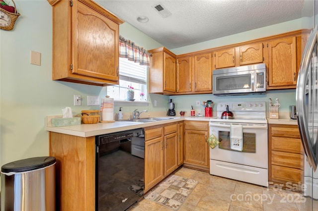 kitchen with visible vents, light countertops, appliances with stainless steel finishes, a textured ceiling, and a sink