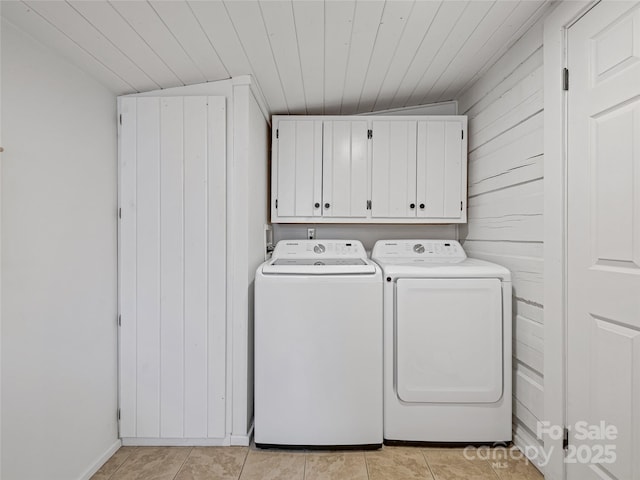 clothes washing area featuring cabinet space, light tile patterned floors, wooden ceiling, and separate washer and dryer