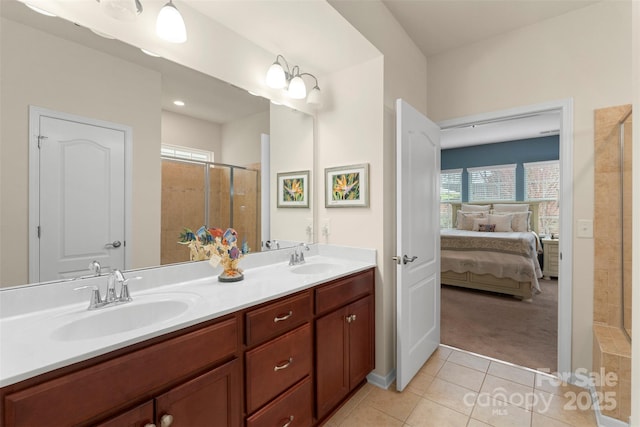 bathroom featuring a stall shower, double vanity, a sink, and tile patterned floors