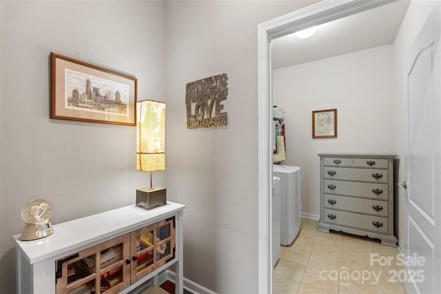 laundry room featuring laundry area, light tile patterned flooring, and washing machine and clothes dryer