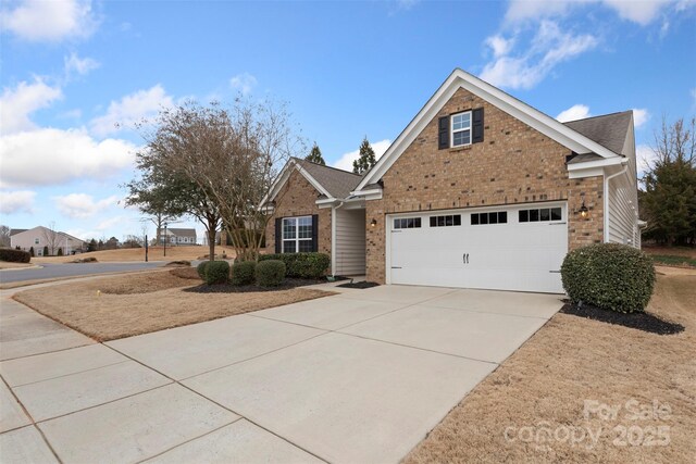 traditional home featuring a garage, brick siding, and driveway