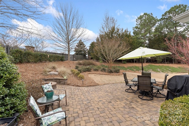 view of patio with grilling area, fence, and outdoor dining area