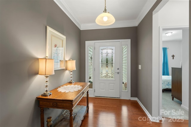 entryway featuring ornamental molding, baseboards, and wood finished floors