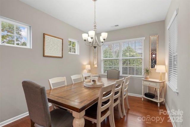 dining space featuring a chandelier, dark wood-style flooring, visible vents, and baseboards