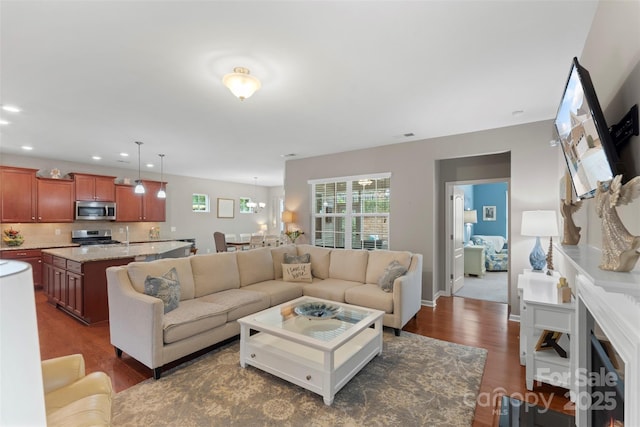 living room featuring recessed lighting, dark wood-style flooring, and baseboards