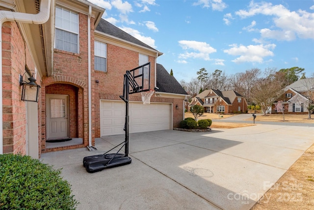 view of property exterior featuring brick siding, a shingled roof, concrete driveway, a garage, and a residential view