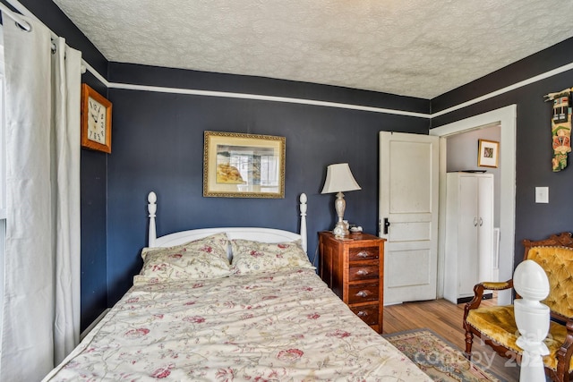 bedroom featuring a textured ceiling and wood finished floors