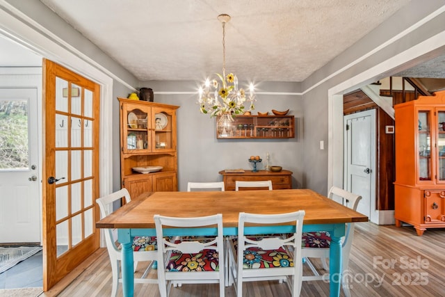 dining room featuring light wood finished floors and a chandelier