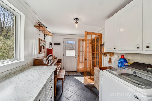 laundry area featuring washer / clothes dryer, dark tile patterned flooring, and cabinet space