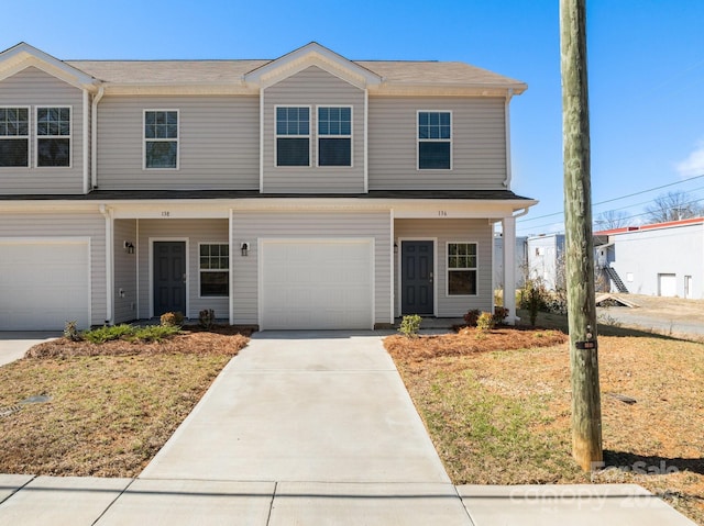 view of front of house with a front yard, concrete driveway, and an attached garage