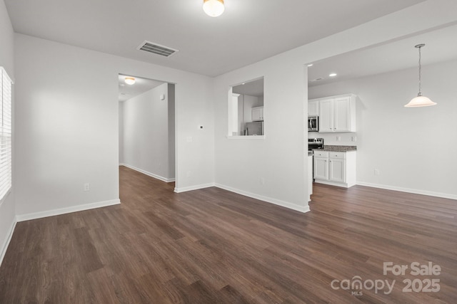 unfurnished living room featuring dark wood-type flooring, recessed lighting, visible vents, and baseboards