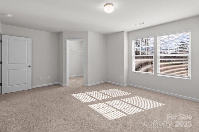 unfurnished room featuring visible vents, baseboards, and light colored carpet