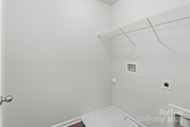 clothes washing area featuring laundry area, washer hookup, electric dryer hookup, and baseboards