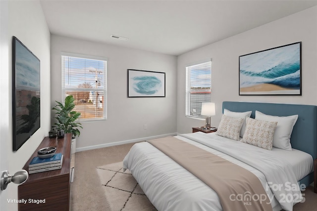 carpeted bedroom with visible vents and baseboards