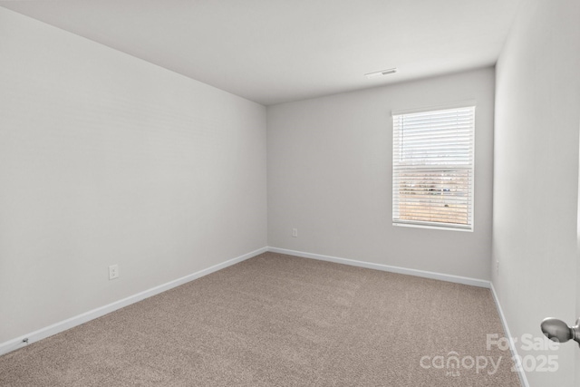 carpeted spare room featuring baseboards